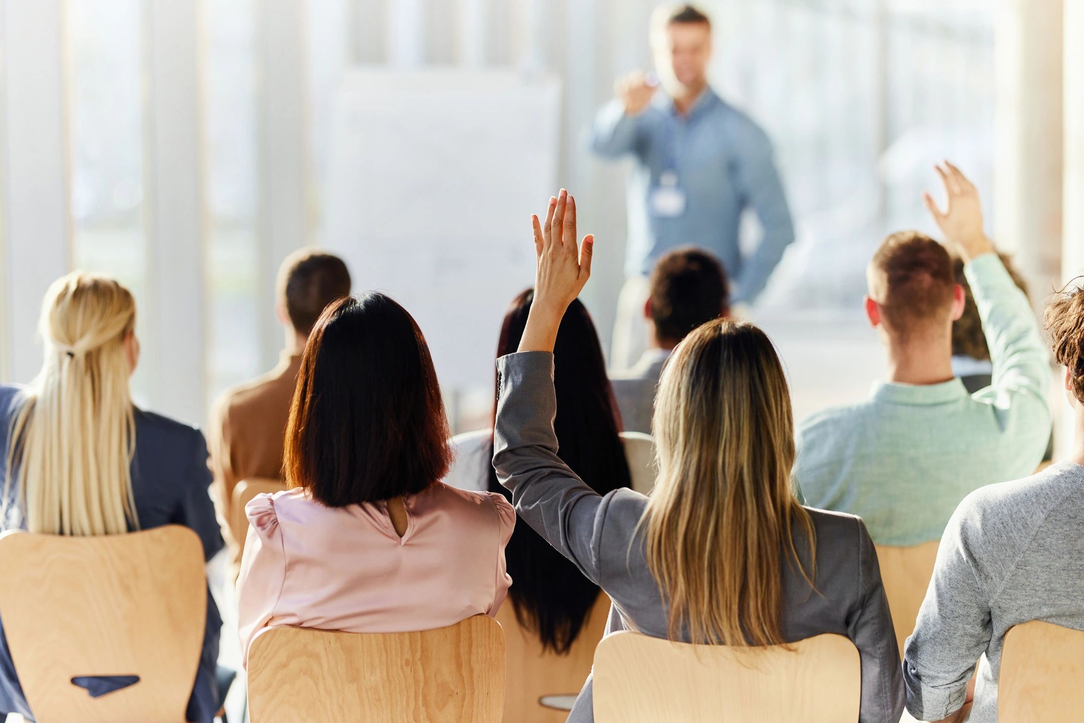 Real estate professionals in a training workshop raising a question